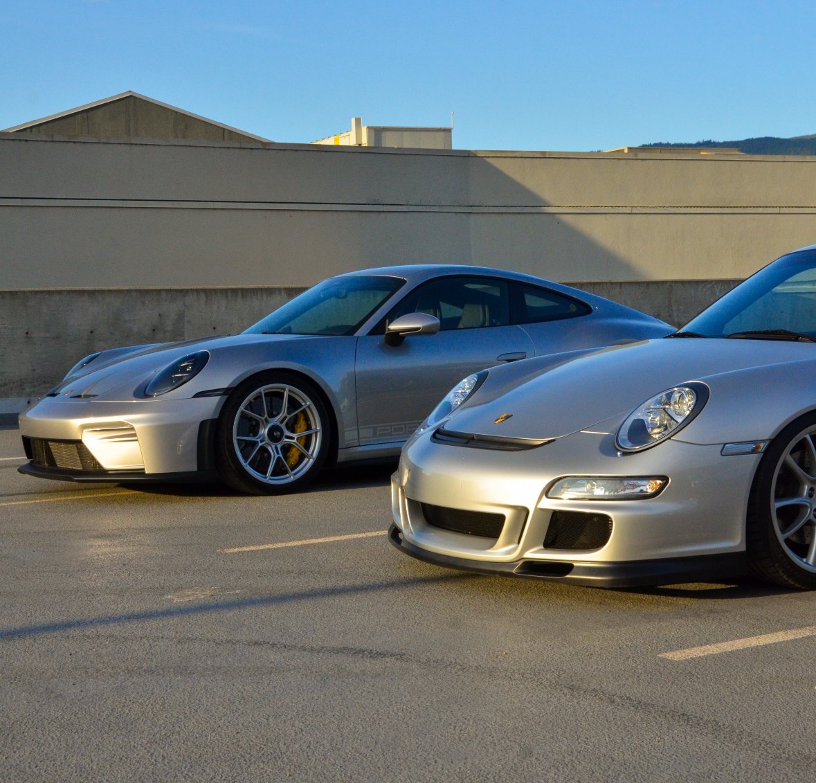 Two silver Porsche sports cars photographed outdoors